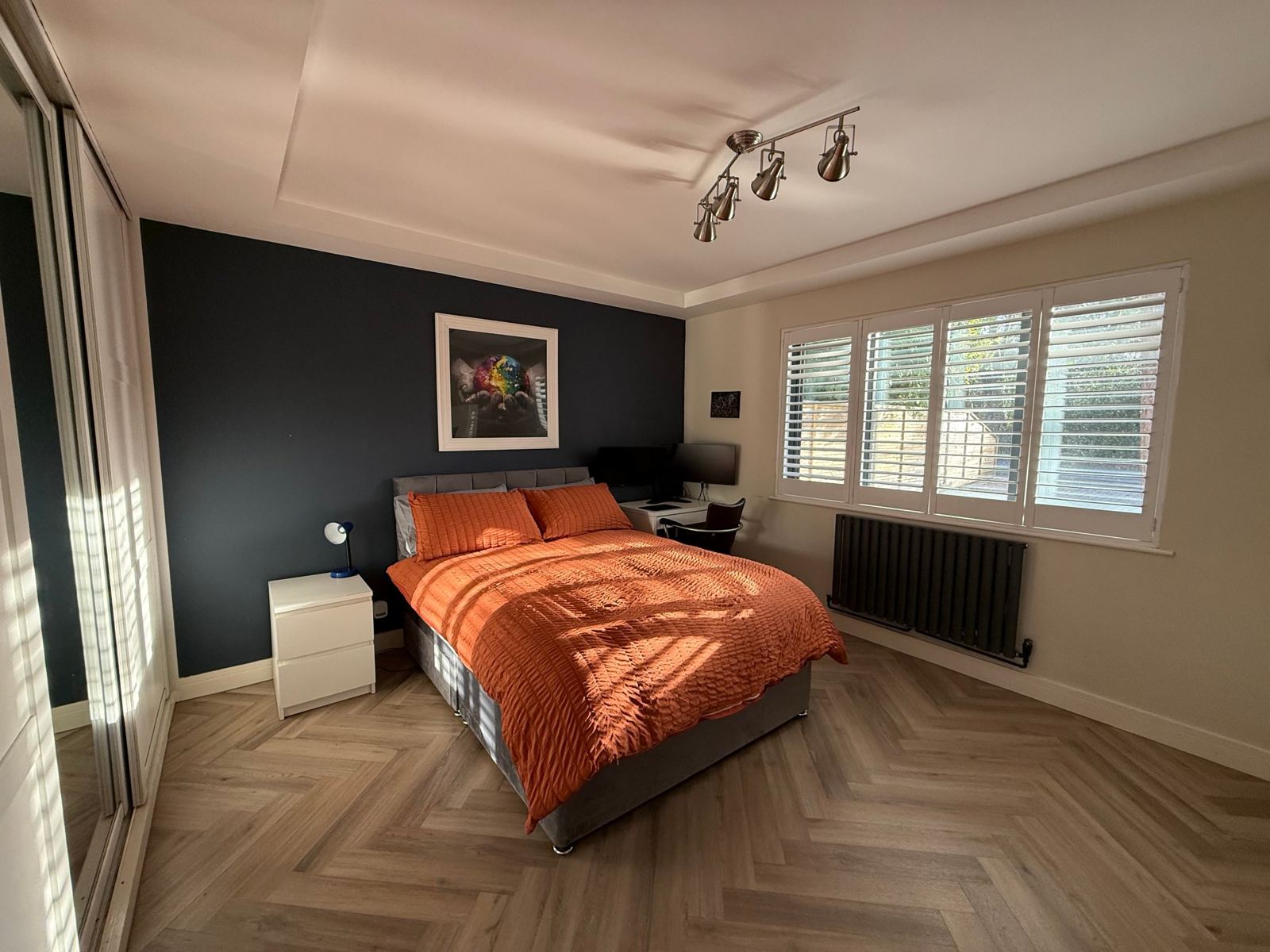Double bedroom with a desk and plantation shutters
