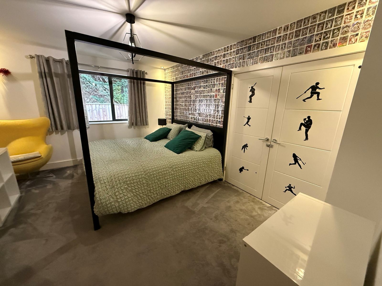 A second four-poster bedroom with a baseball-themed wall