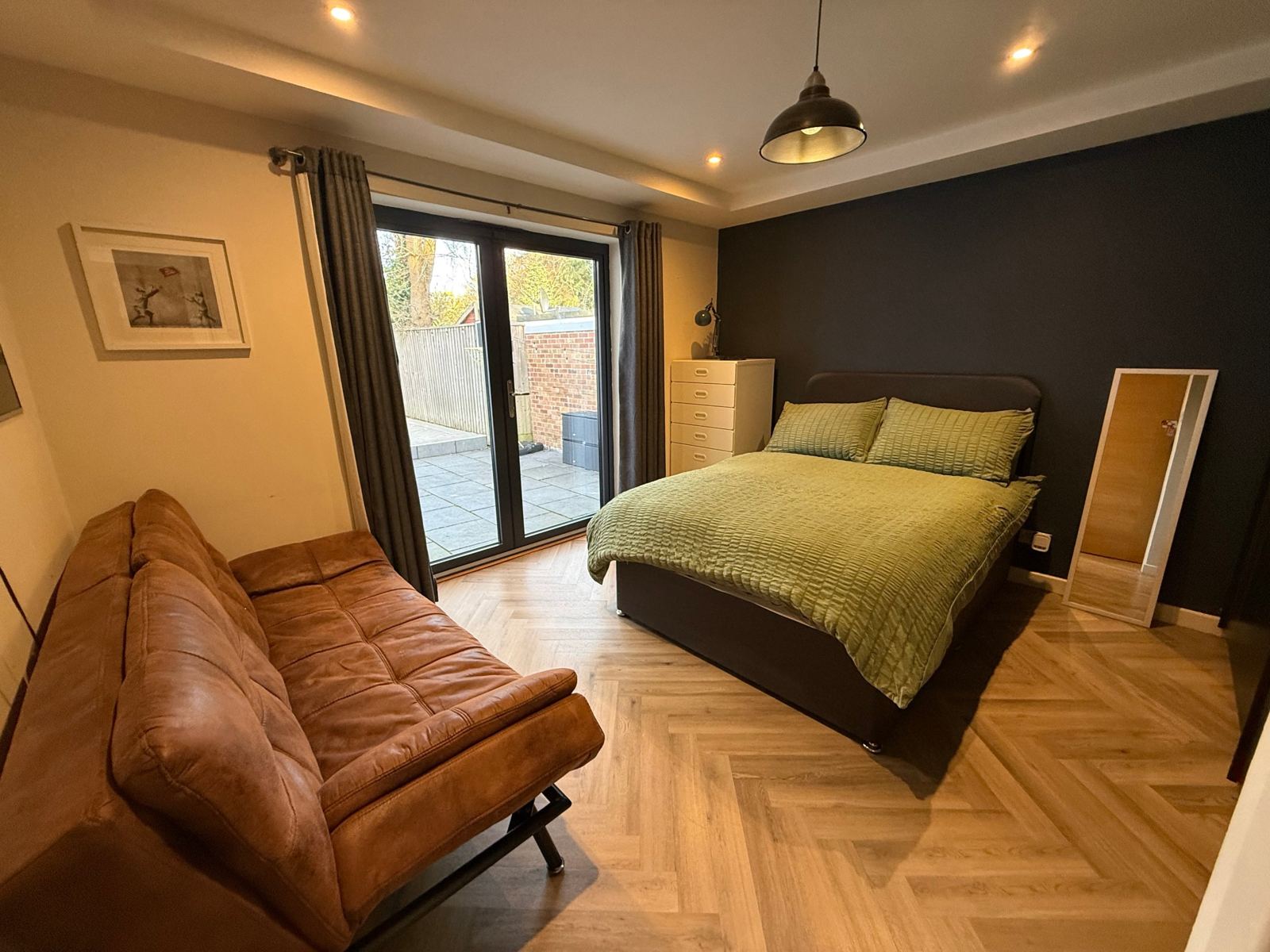 Double bedroom with French doors and a sofa