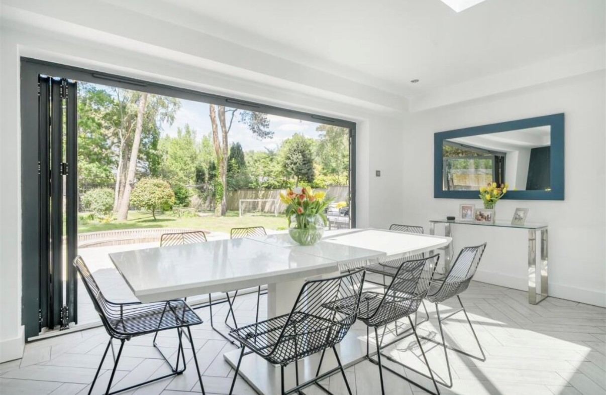 Dining table beside bi-fold doors that open onto the garden